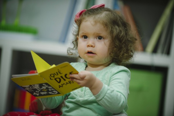 niña pequeña sosteniendo un libro para niños