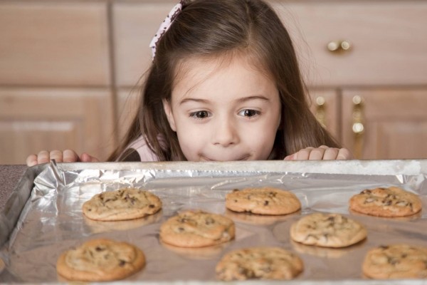 niña mirando galletas recién hechas