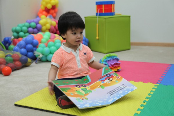 niño pequeño jugando con un libro gigante