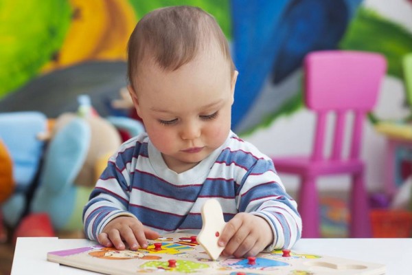 bebé jugando con un rompecabezas de clavijas