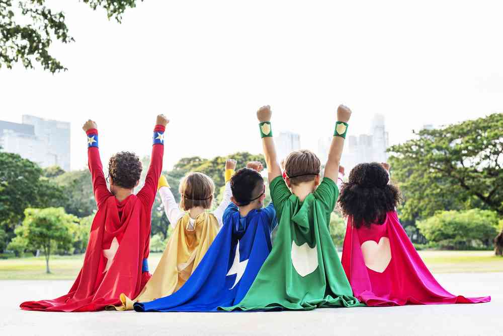 niños vestidos con capas de superhéroes