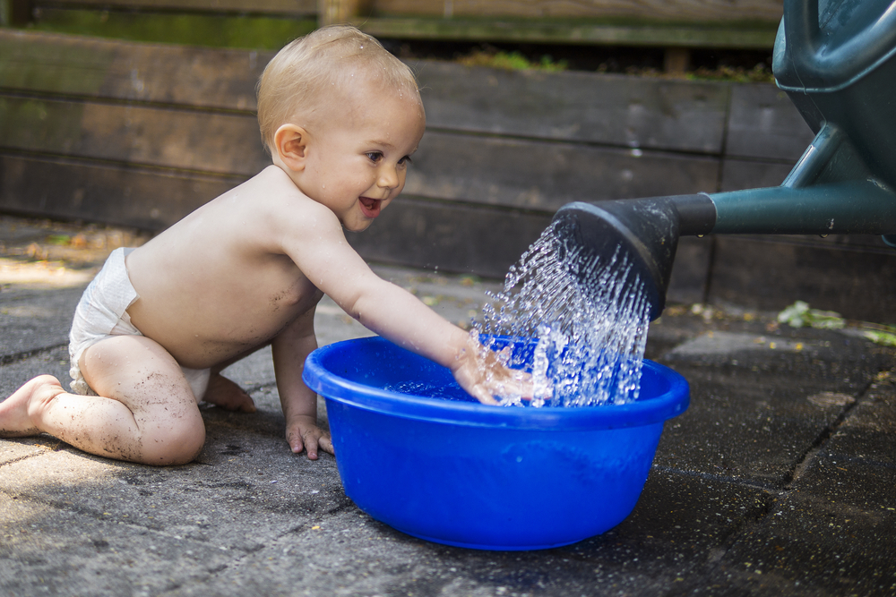 bebé jugando con agua