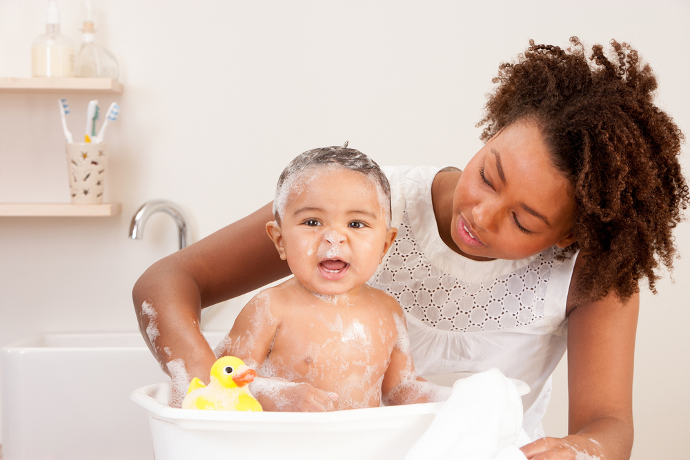 madre bañando a su bebé en una tina