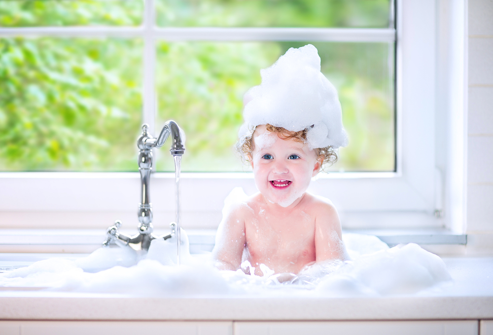 niño pequeño tomando un baño de burbujas