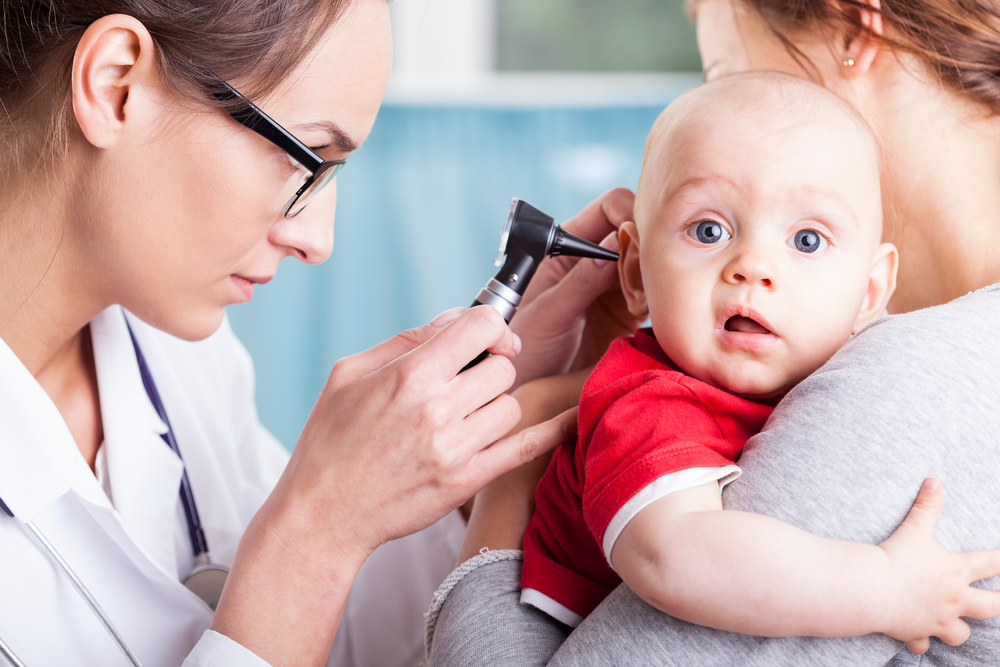 pediatra revisando el oído de un bebé