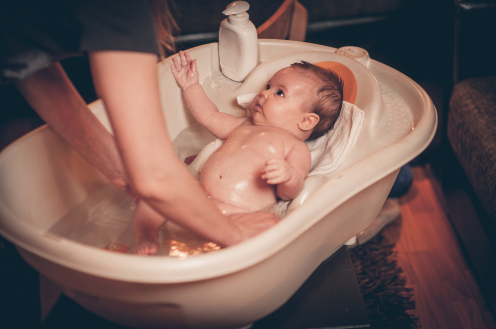 madre bañando a su bebé