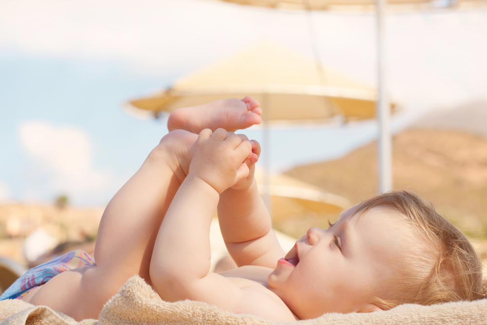 bebé en la playa jugando con sus pies