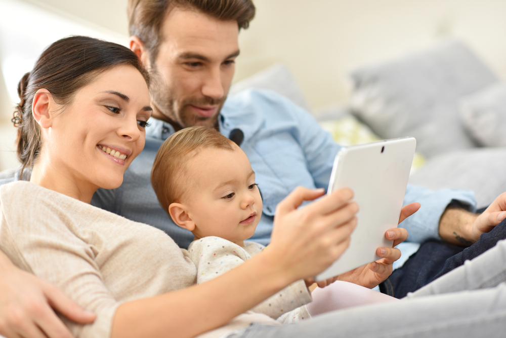 padres y bebé usando una tablet