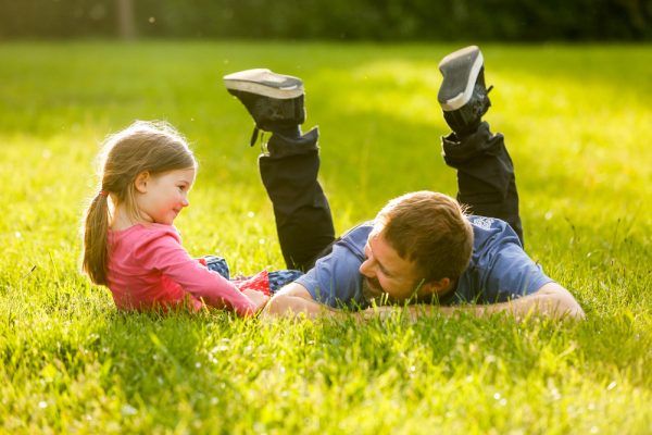niña pequeña hablando con su papá al aire libre