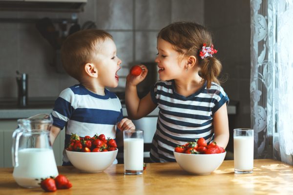 niños pequeños comiendo fresas