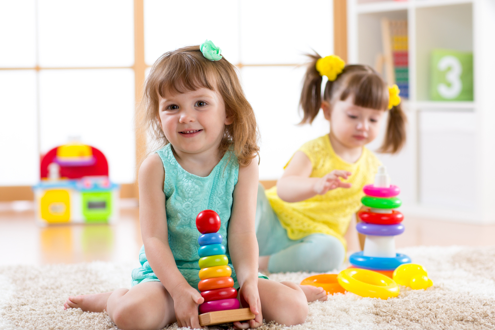 dos niñas jugando con juguetes de colores