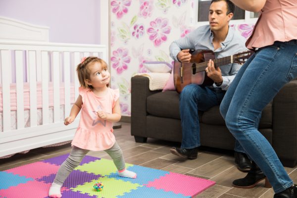 niña pequeña bailando mientras papá toca la guitarra