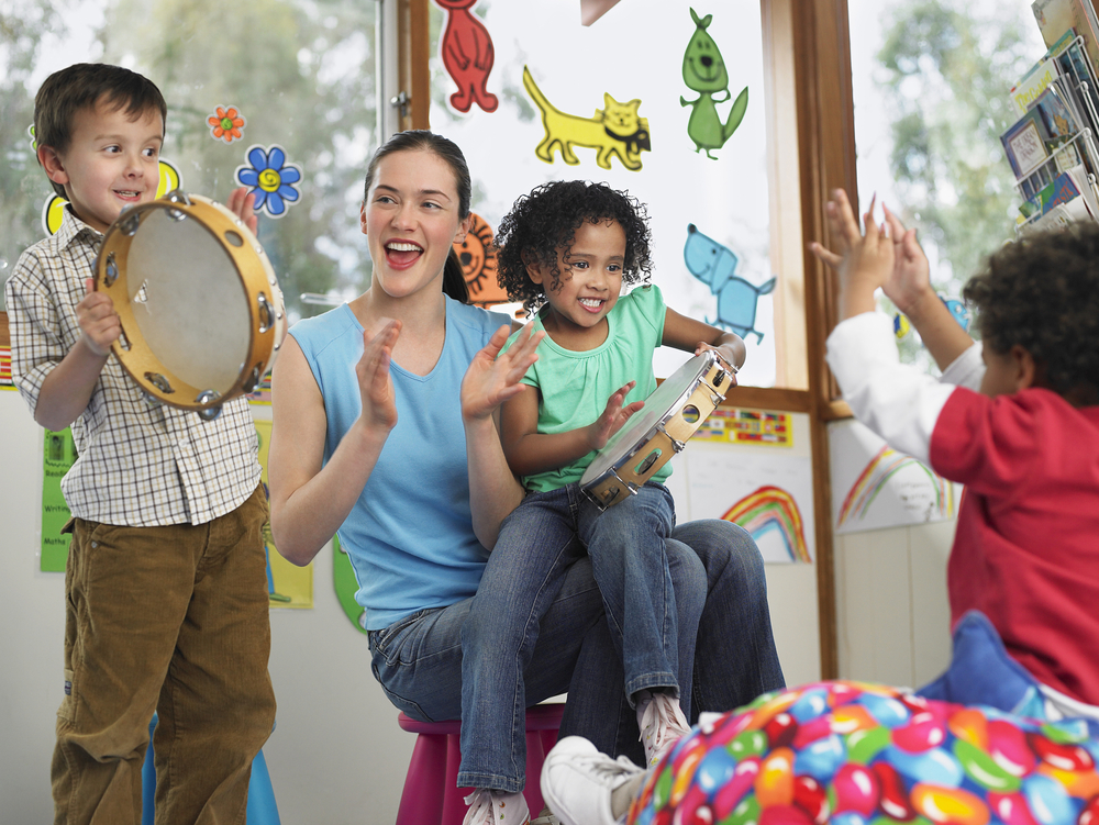 mujer y niños jugando con instrumentos musicales