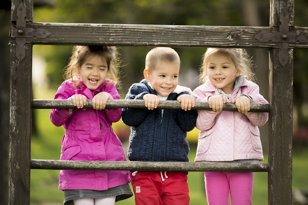 un niño y dos niñas sonriendo