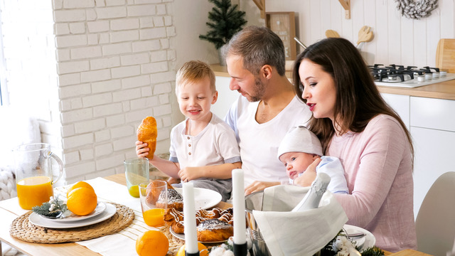 papás, bebé y niño pequeño desayunando