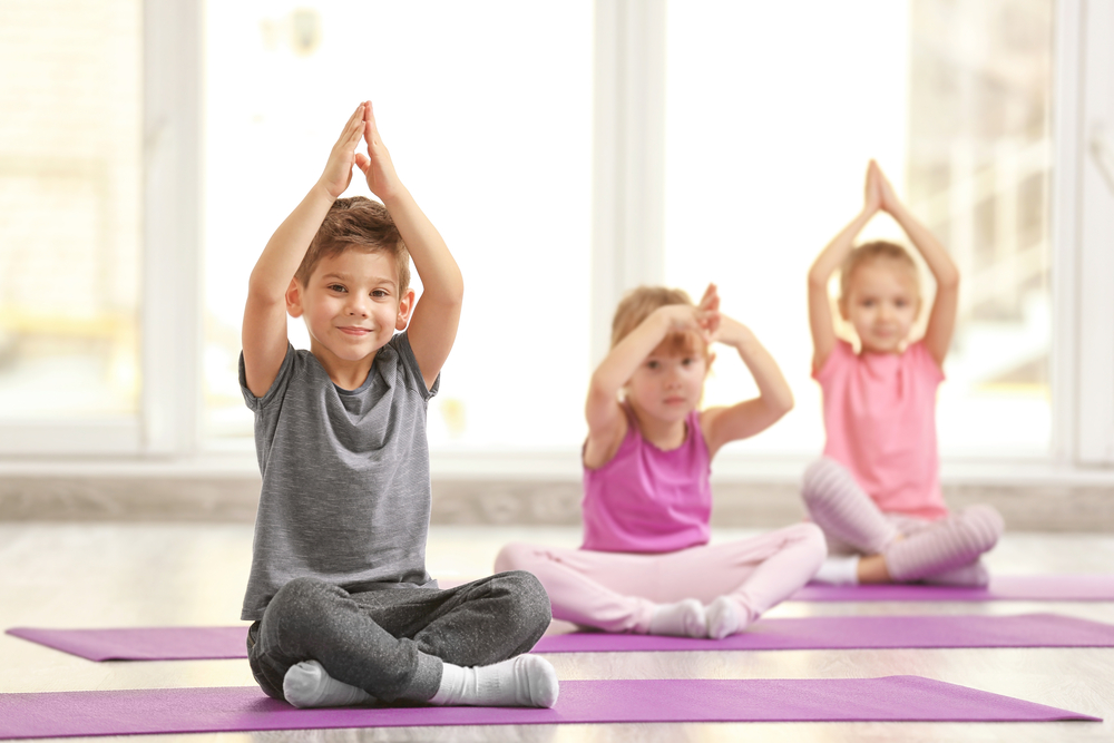niños pequeños practicando yoga