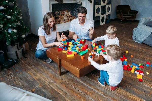 padres y sus hijos jugando juntos con bloques de juguete