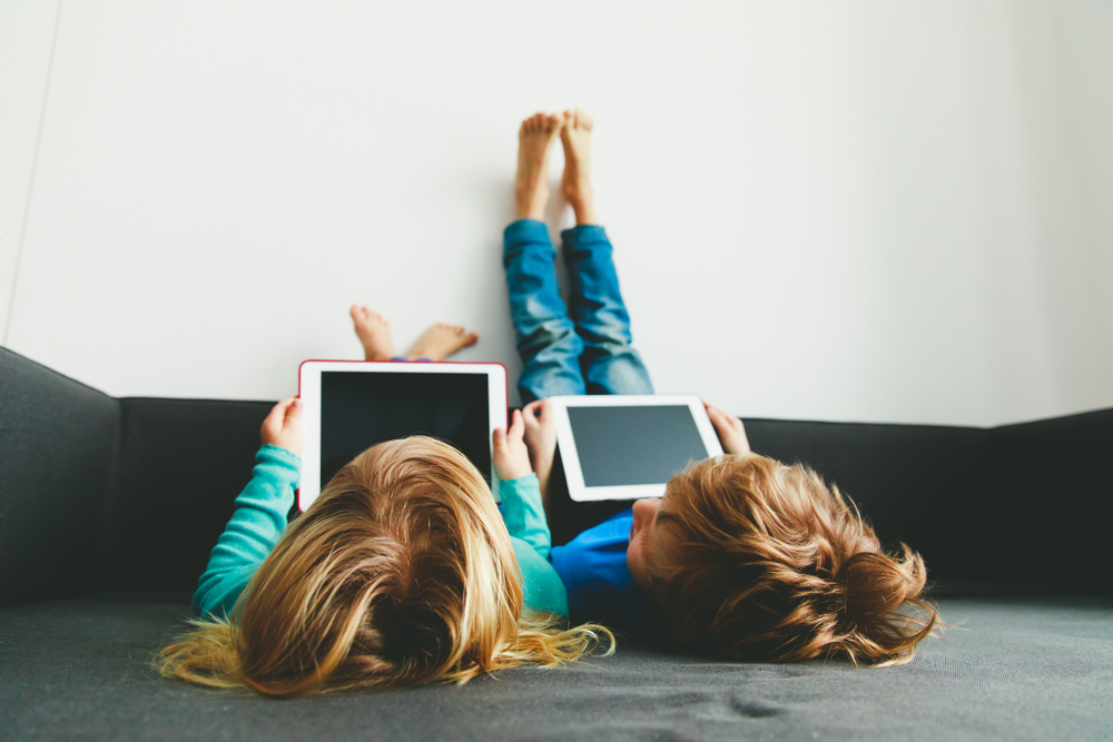 dos niños pequeños usando tabletas