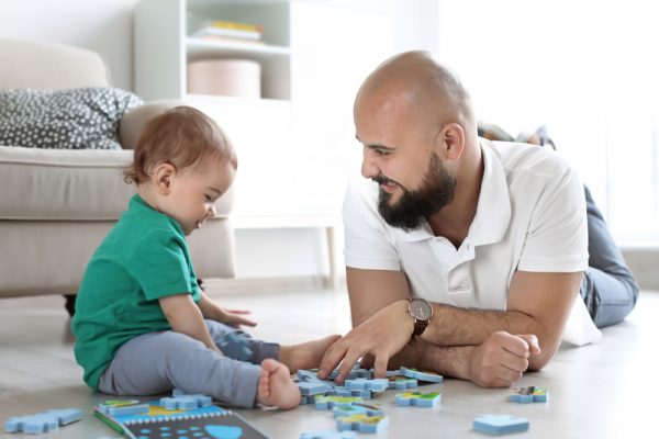 padre y su bebé jugando con un rompecabezas