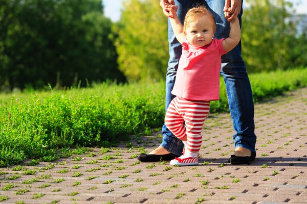 Bebé aprende a caminar dándole la mano a su madre