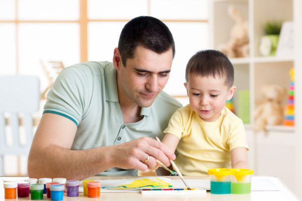padre e hijo pintando juntos en casa