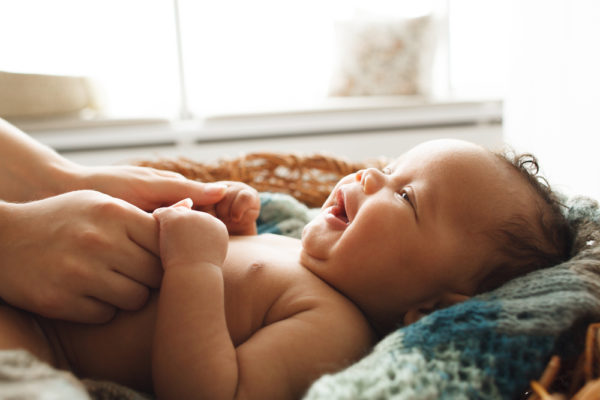 bebé de 2 meses sonriéndole a su cuidador