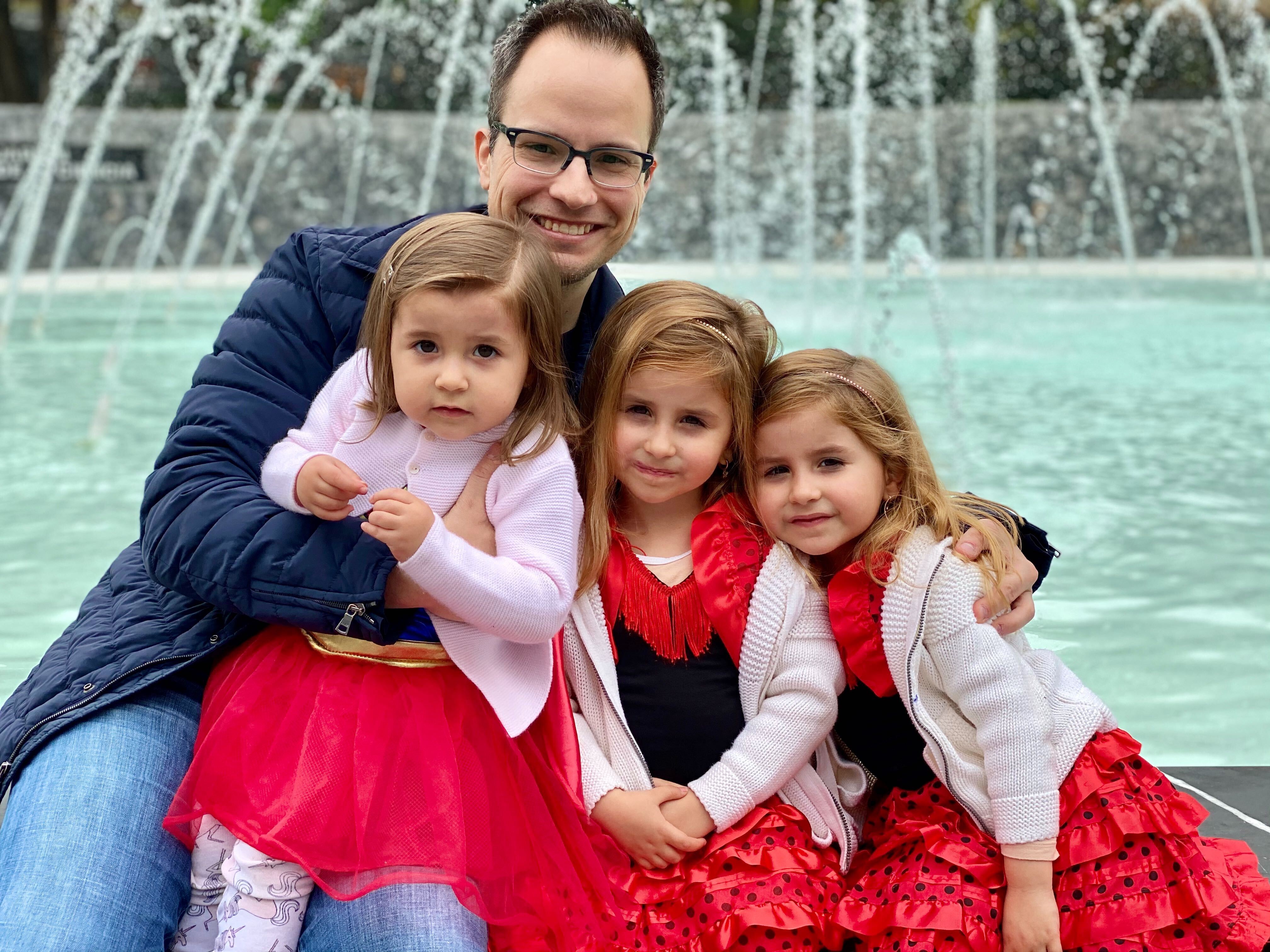 papá feliz con sus tres hijas
